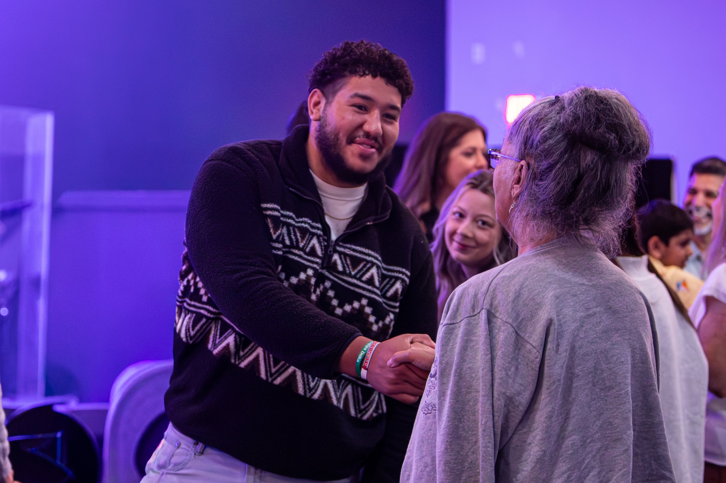 Two people greet one another at a GNCO gathering.
