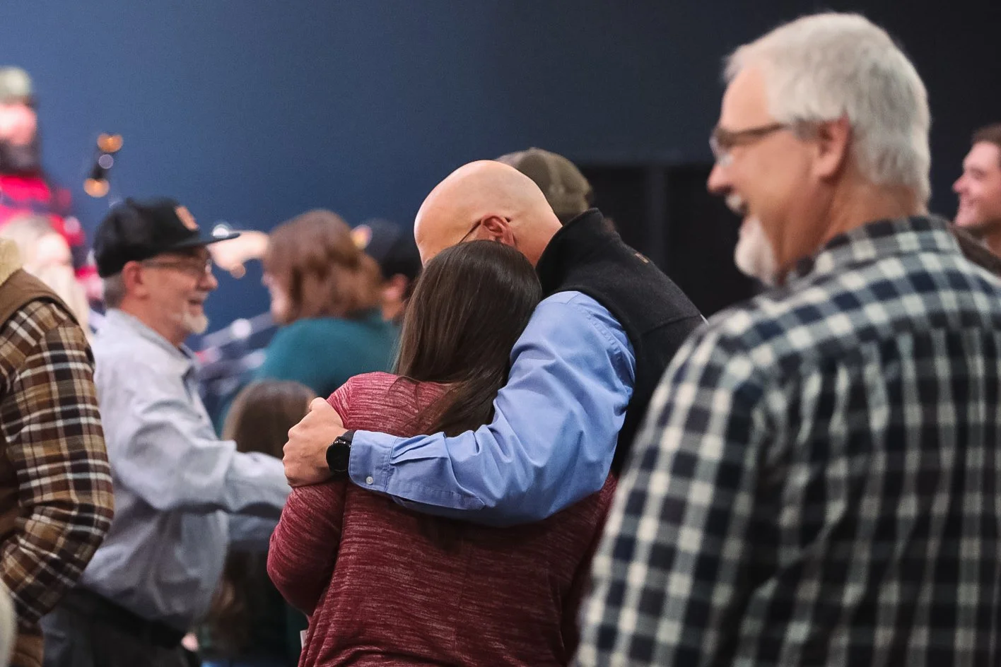 Two people share a supportive embrace at GNCO.