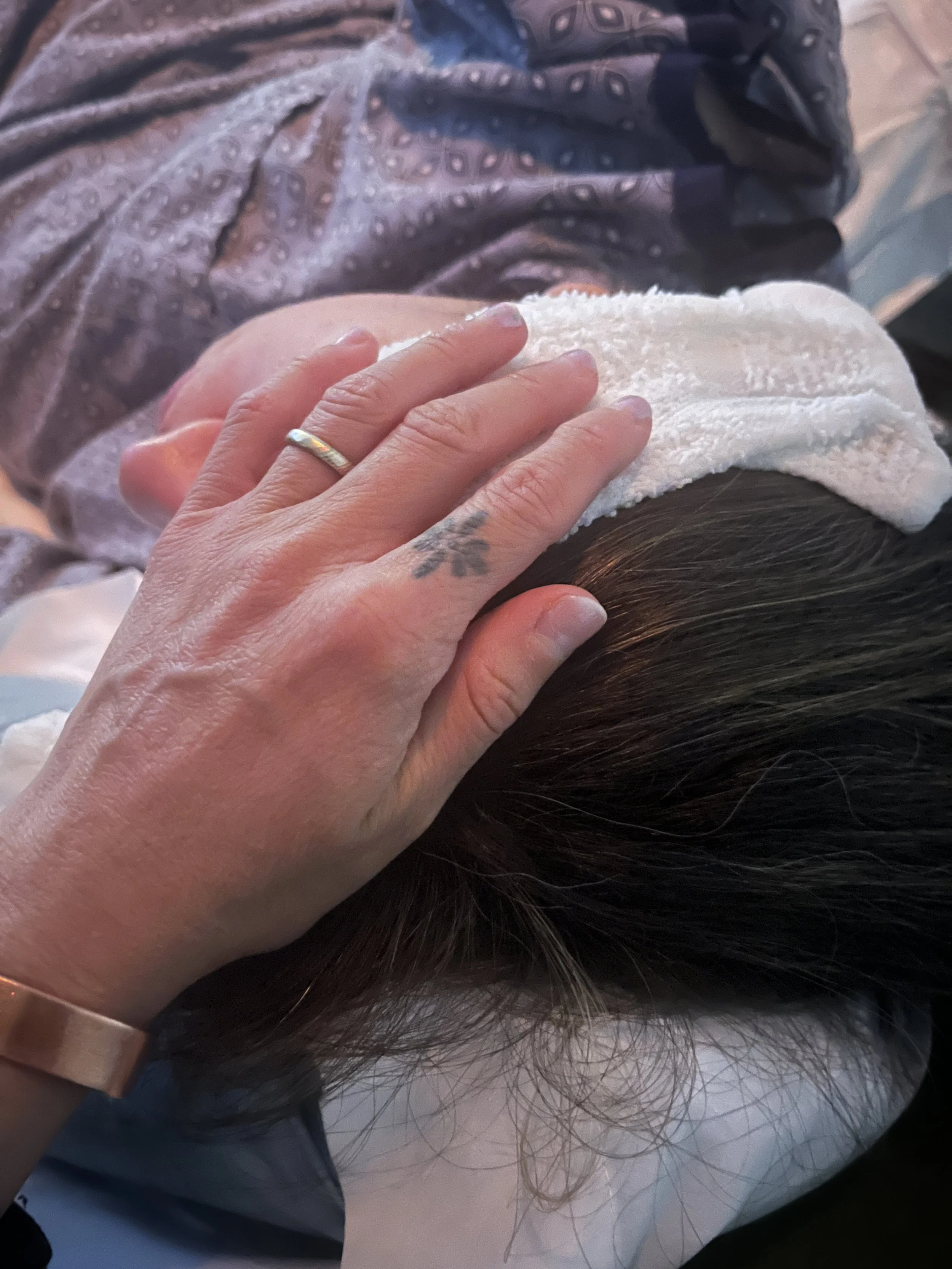Doula holding cool washcloth to client's head during labor
