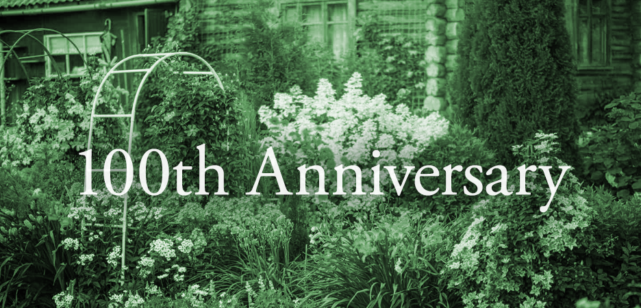 A lush garden scene with flowering plants, bushes, and trees, and a house in the background, with the text '100th Anniversary' overlaid.