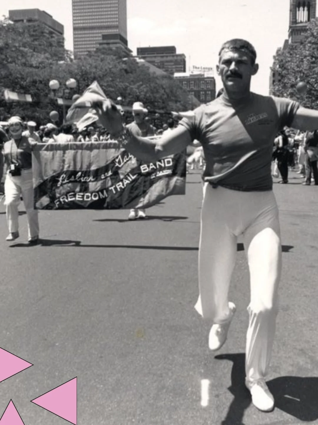 A man twirls a baton and marches through Copley Plaza in front of a banner for the Lesbian and Gay Freedom Trail Band, part of the 1985 Pride parade. 

This photograph is part of our Gay Community News photograph collection. Check it out at historypr