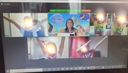 Lezione online di inglese per bambini in piccolo gruppo con insegnante e studenti sorridenti che interagiscono durante un incontro virtuale.