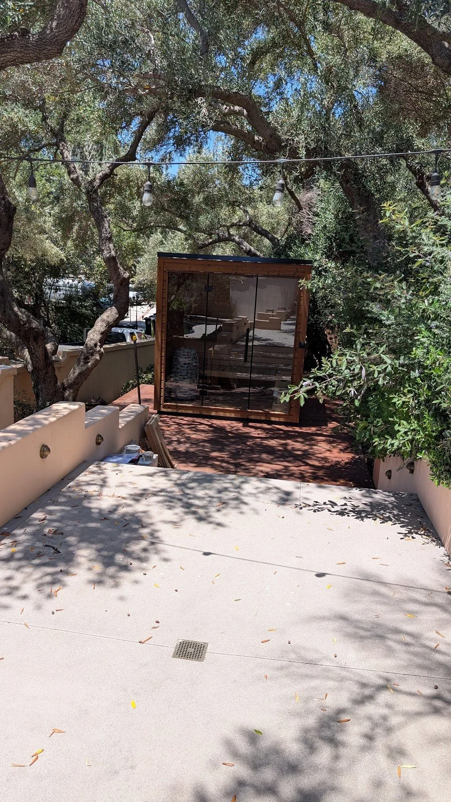 Same install from above: cube sauna on the lower deck, landscaping left intact.