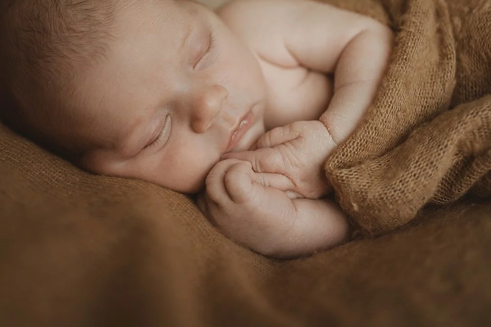 Newborn and baby photographer Bristol - close up of a newborn baby wrapped in a blanket.
