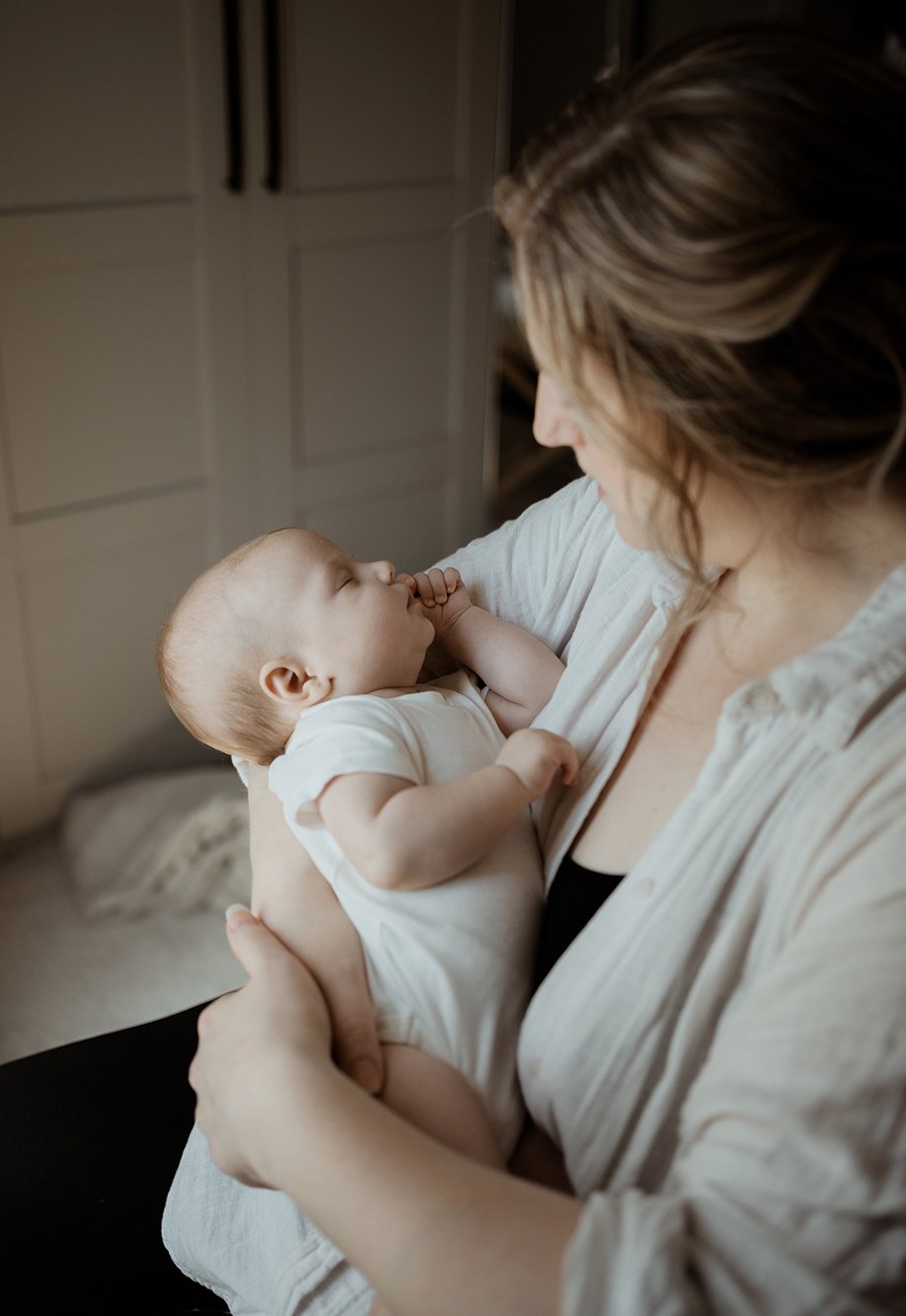 Newborn photographer Bristol - image of a mother holding her baby who is sleeping.