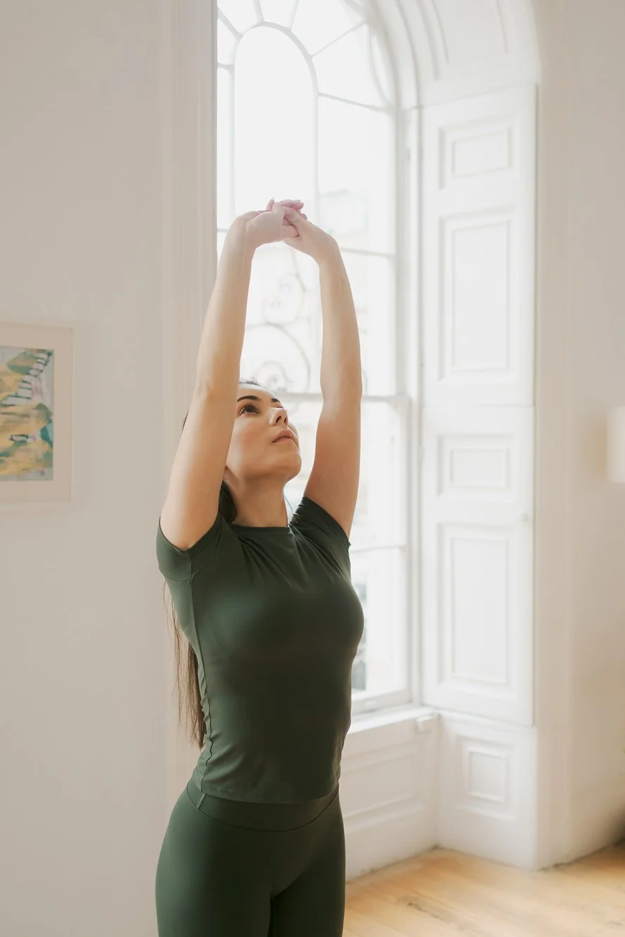 Personal branding photographer in Bath - image of a woman doing pilates, stretching her arms into the air.