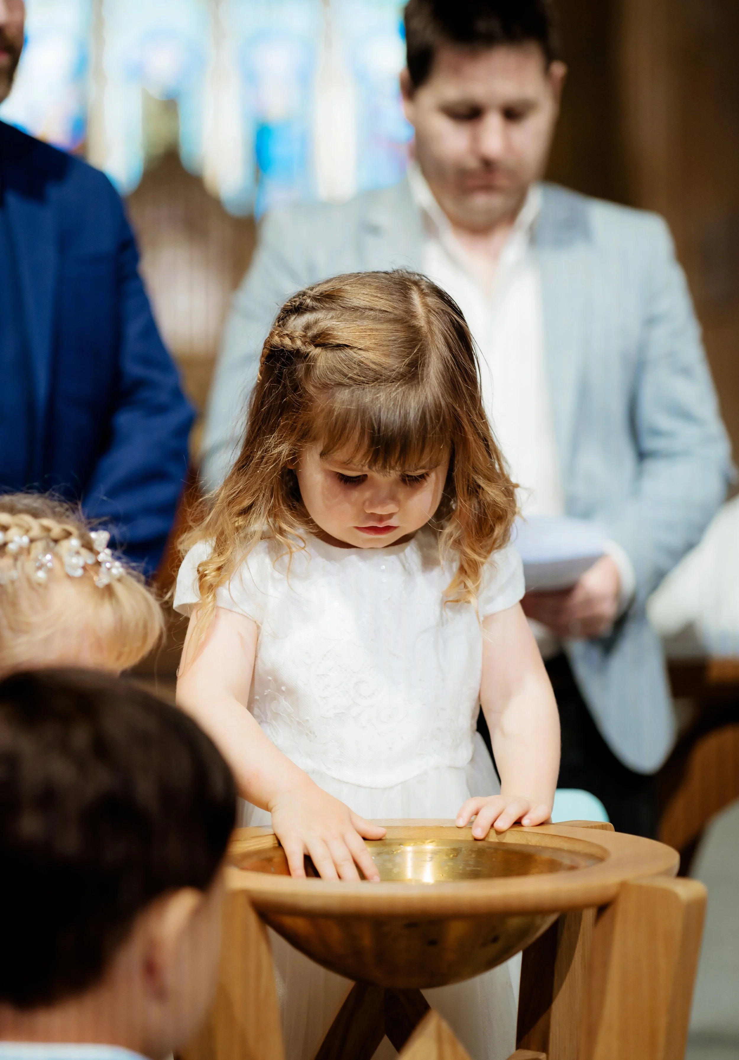Christening photographer Bath - image of a little girl looking at a font.