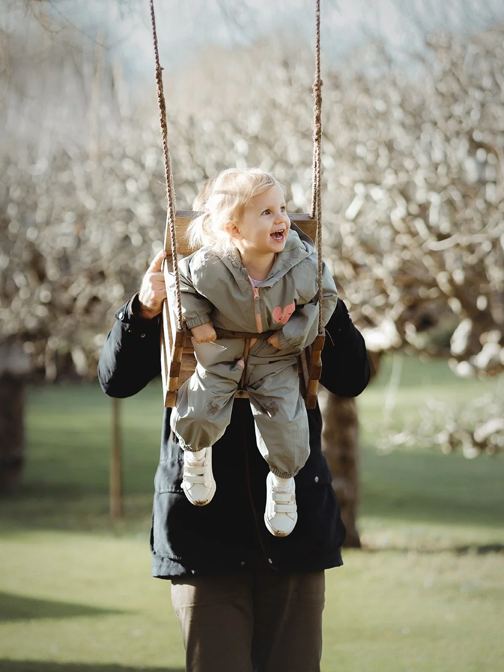 Image of older daughter on a swing during a family photoshoot.
