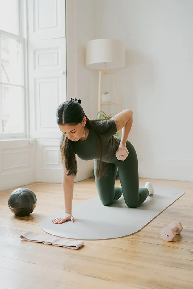 Personal branding photographer - image of a woman doing pilates with weights.