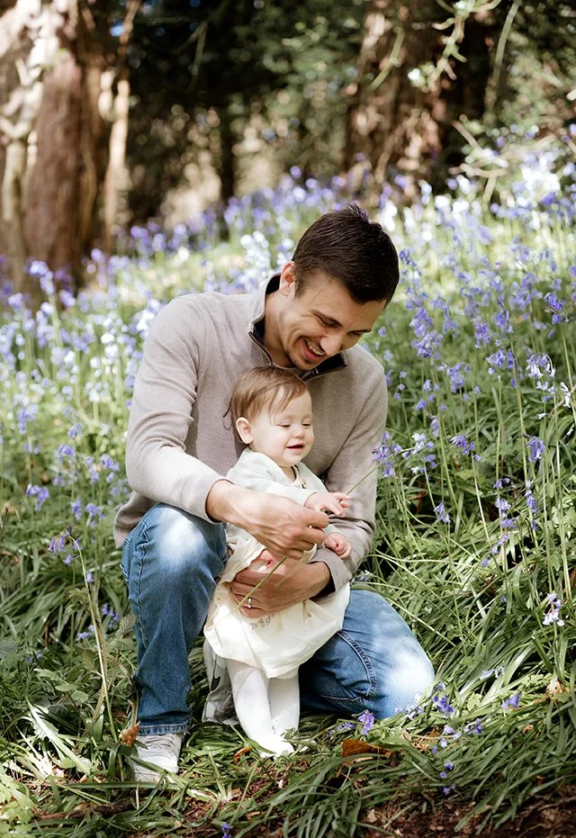 Bristol family photographer - image of a father with his daughter looking at bluebells.