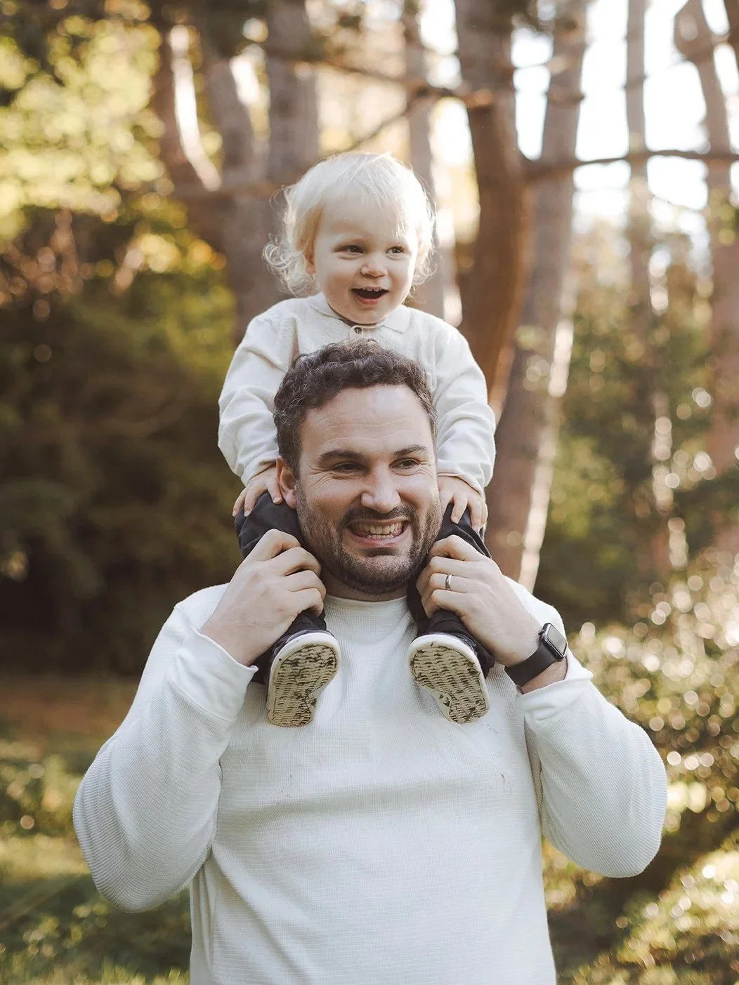 Family photographer Bath - image of a father with his little son on his shoulders during a family photoshoot in Bath
