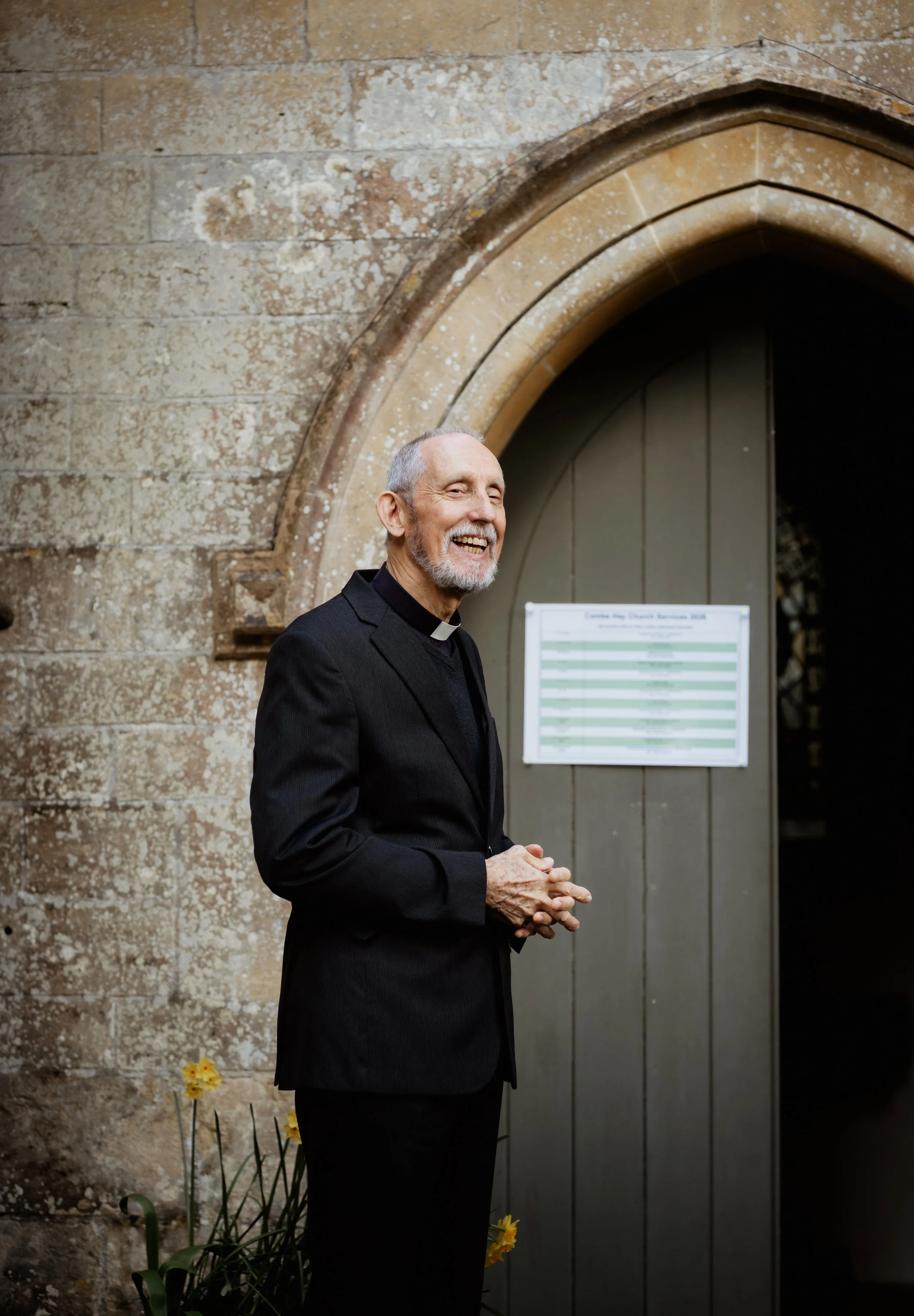 Christening photographer Bath - image of a priest standing outside his church in Bath.