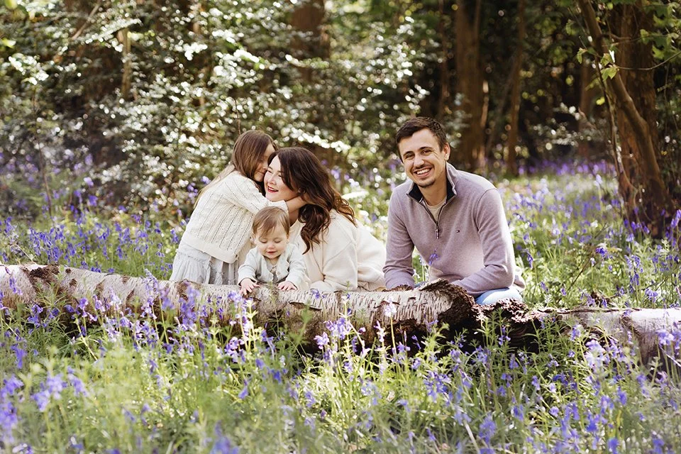 Image of a family sitting together in bluebells at Ashton Court in Bristol.