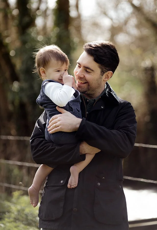 Father carrying his little boy during a family photoshoot.