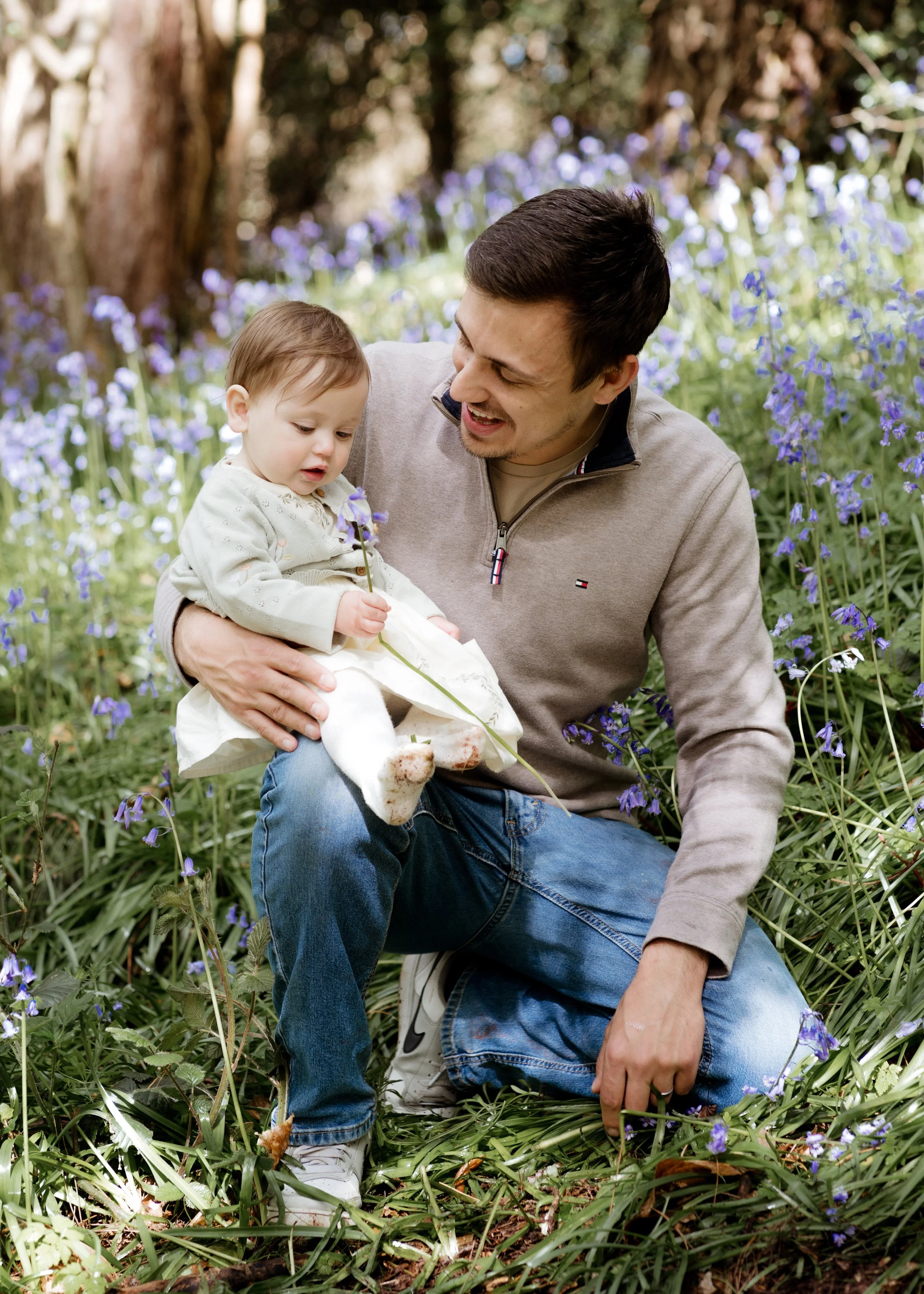Bristol family photographer - image of a father with his daughter looking at bluebells.