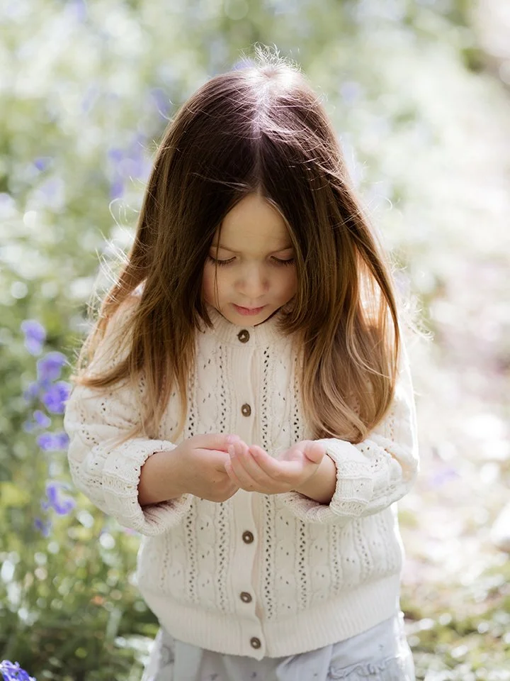 Bristol family photographer - image of a little girl inspecting something in her hands.