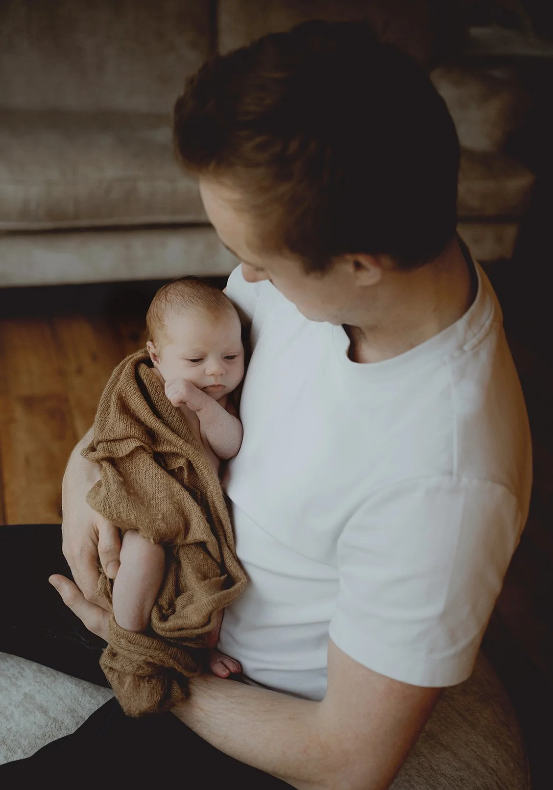 Father holding newborn baby during a newborn photoshoot.