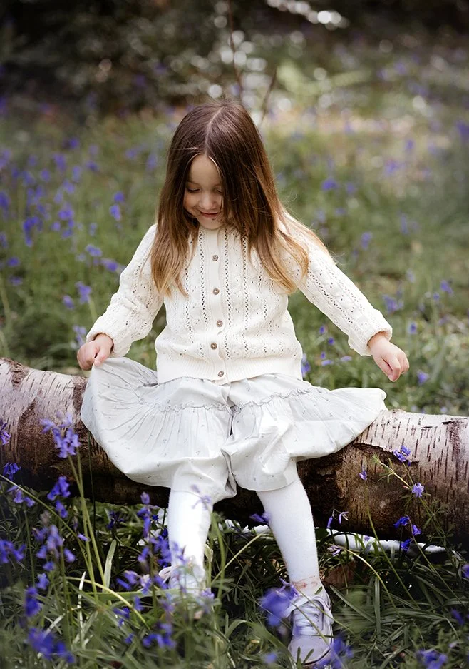 Oldest daughter sitting on a log during a family photoshoot in Bristol