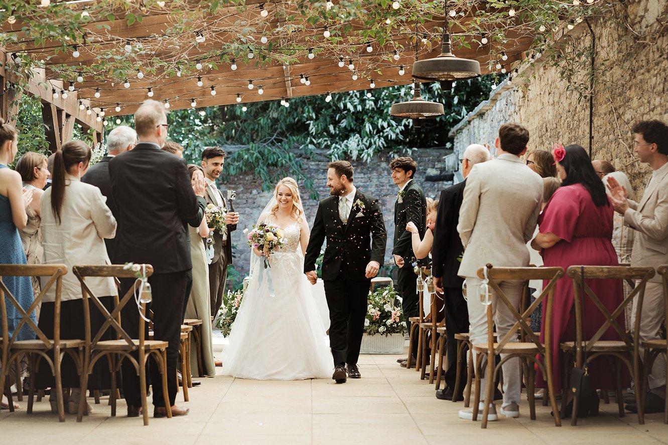 Image of the couple walking down the aisle after getting married.
