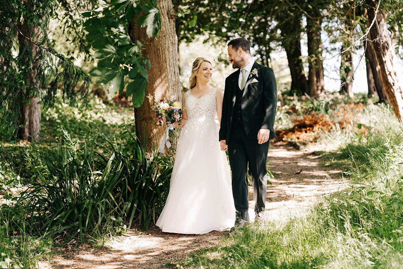Image of wedding couple walking through woods at Old Down Estate near Bristol.