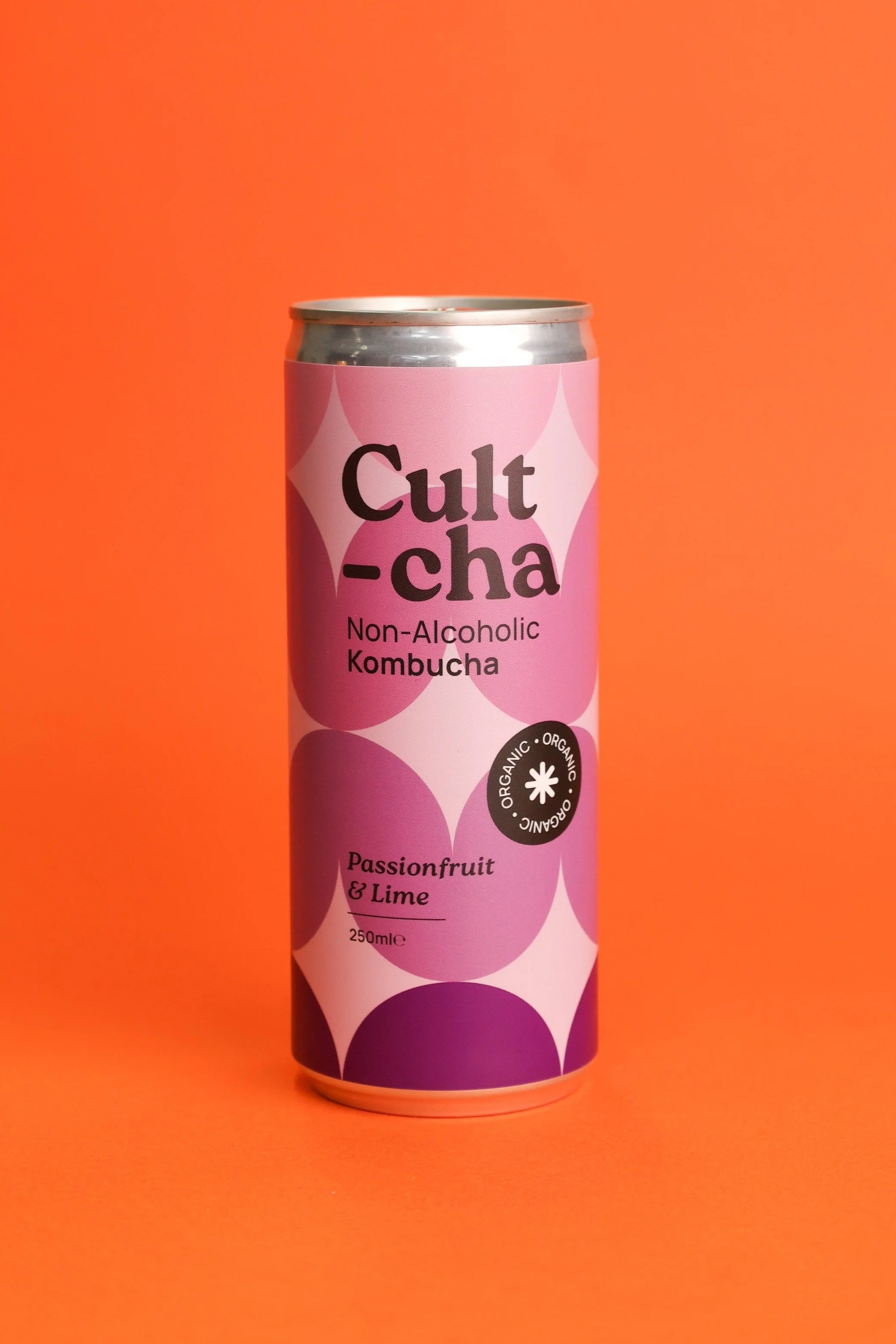 A can of Cult-cha Non-Alcoholic Kombucha with Passionfruit and Lime flavor on an orange background.