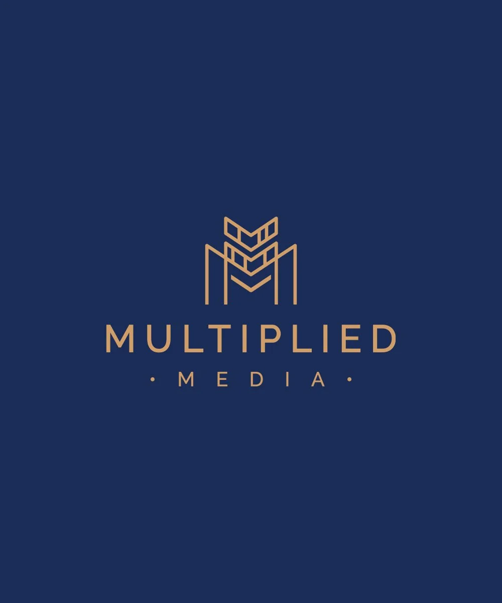 Dark blue background with a gold minimalist logo design of a geometric lion head above the text 'MULTIPLIED MEDIA' in gold capital letters.