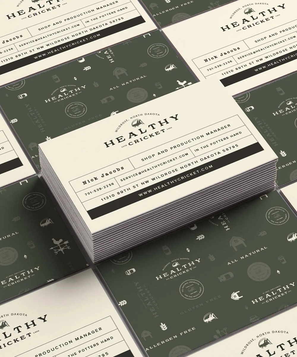 Stack of business card designs for Healthy Cricket, a cricket shop and production company, featuring a white front side with black text and a green back side with subtle cricket-related icons and logos.