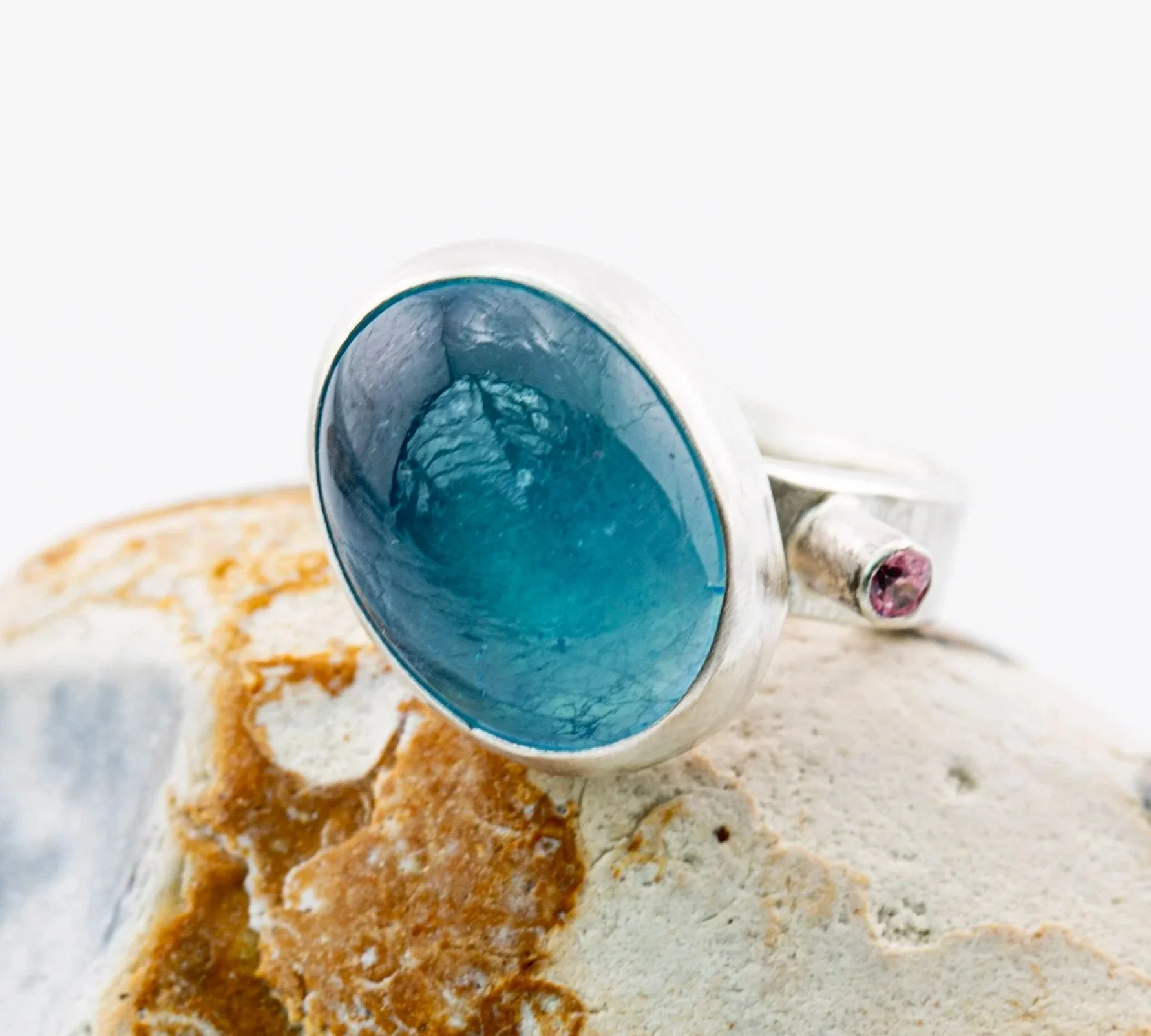 Sterling+Silver+hammered+band+with+bezel+set+aquamarine+cabochon+and+tube+set+pink+cz+on+stone.jpg
