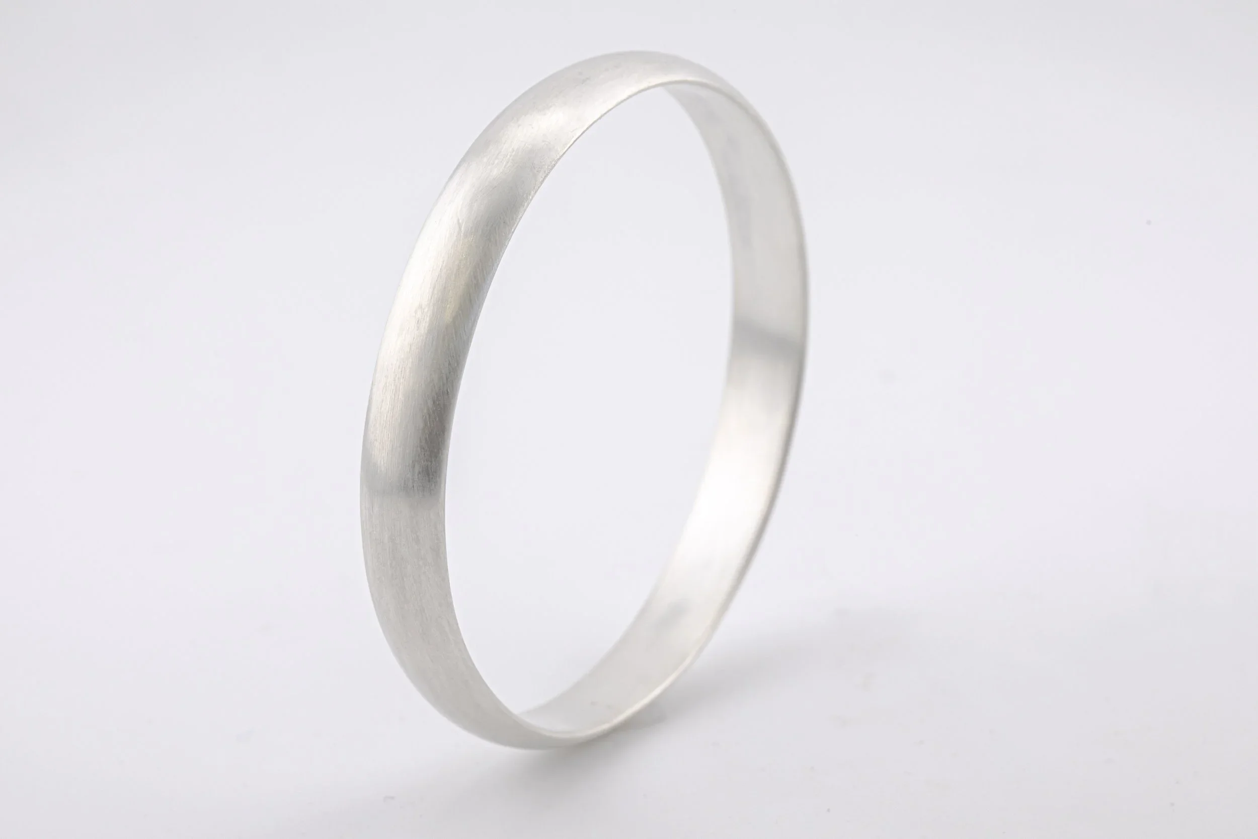Satin+finish+bangle+in+d-shape+Sterling+Silver+upright+view (1).webp