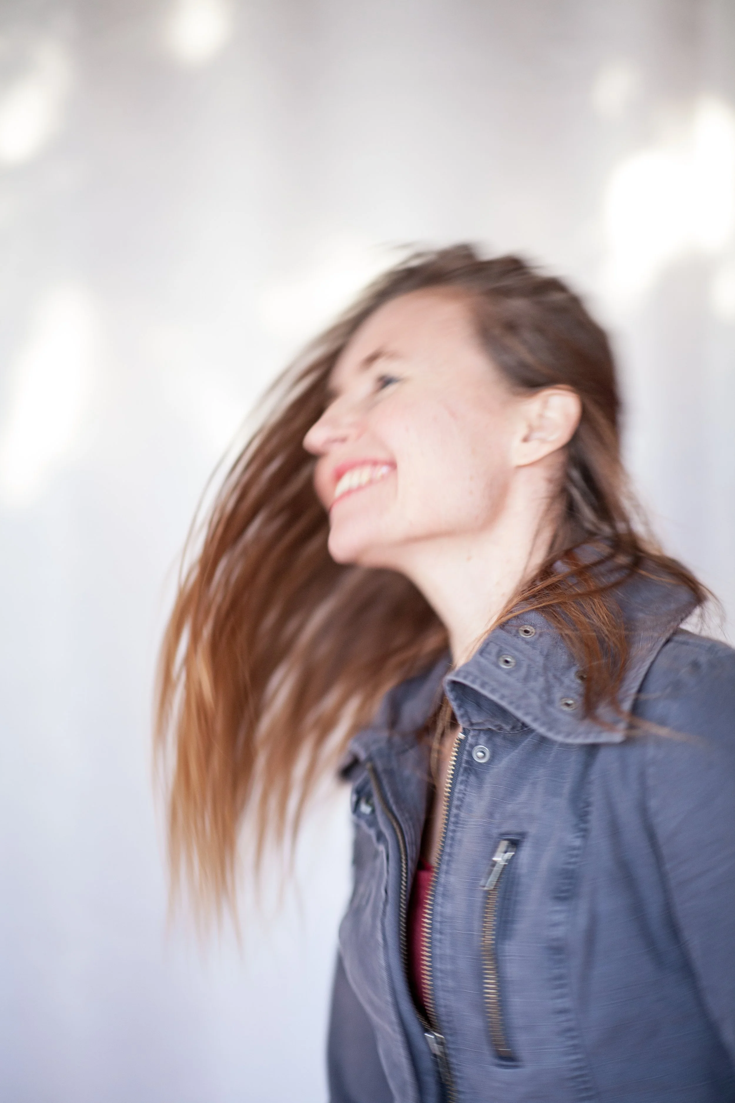 Anita Stryker, speech-language pathologist in Portland, Oregon. A woman with long brown hair smiling and looking to the side, wearing a denim jacket.