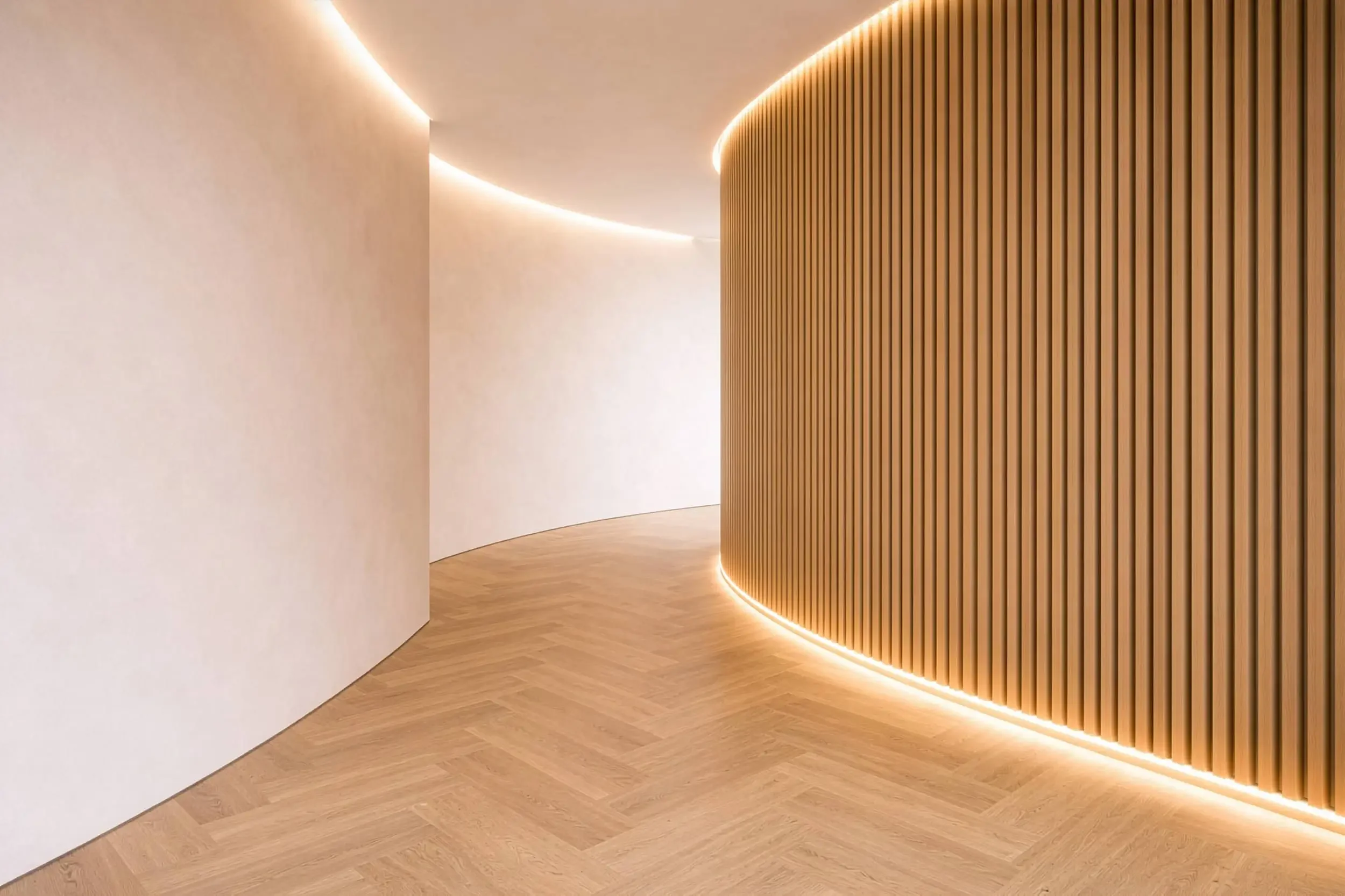 Modern room with curved, lime-washed neutral walls, and a wooden vertical slat wall with LED lights and light oak floors.
