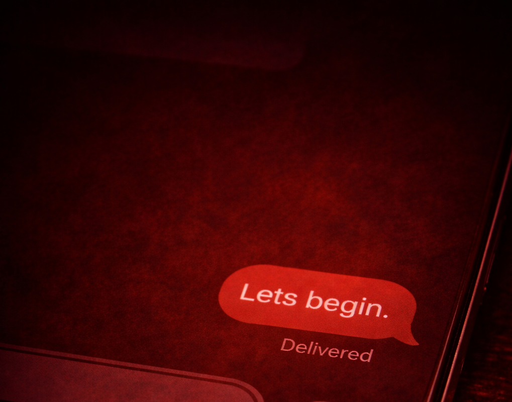 Smartphone screen displaying a text message conversation with the words "Lets begin." in a red speech bubble.