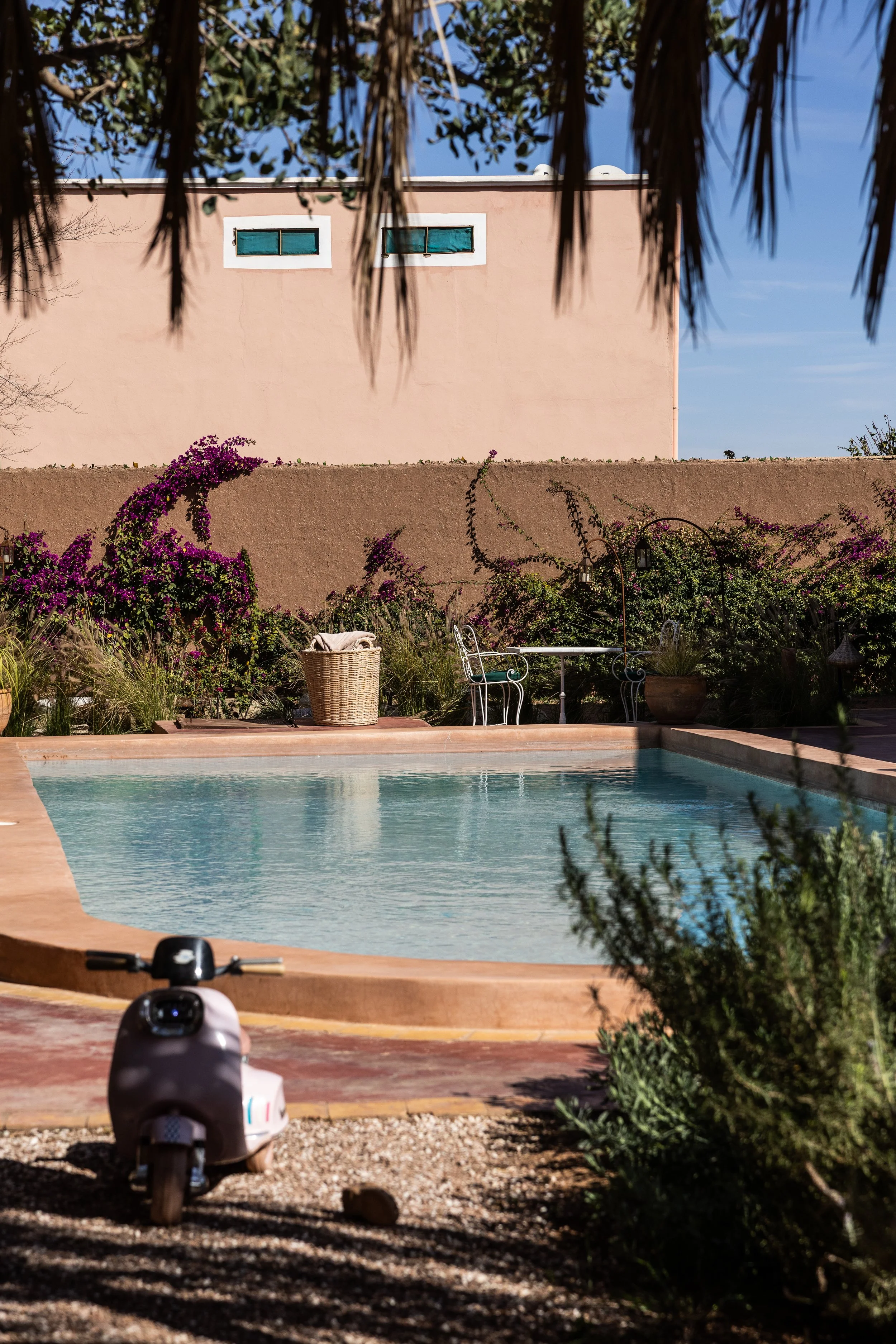 A backyard with a swimming pool, surrounded by flowering bushes in Farmhouse for cooking classes in Marrakech
