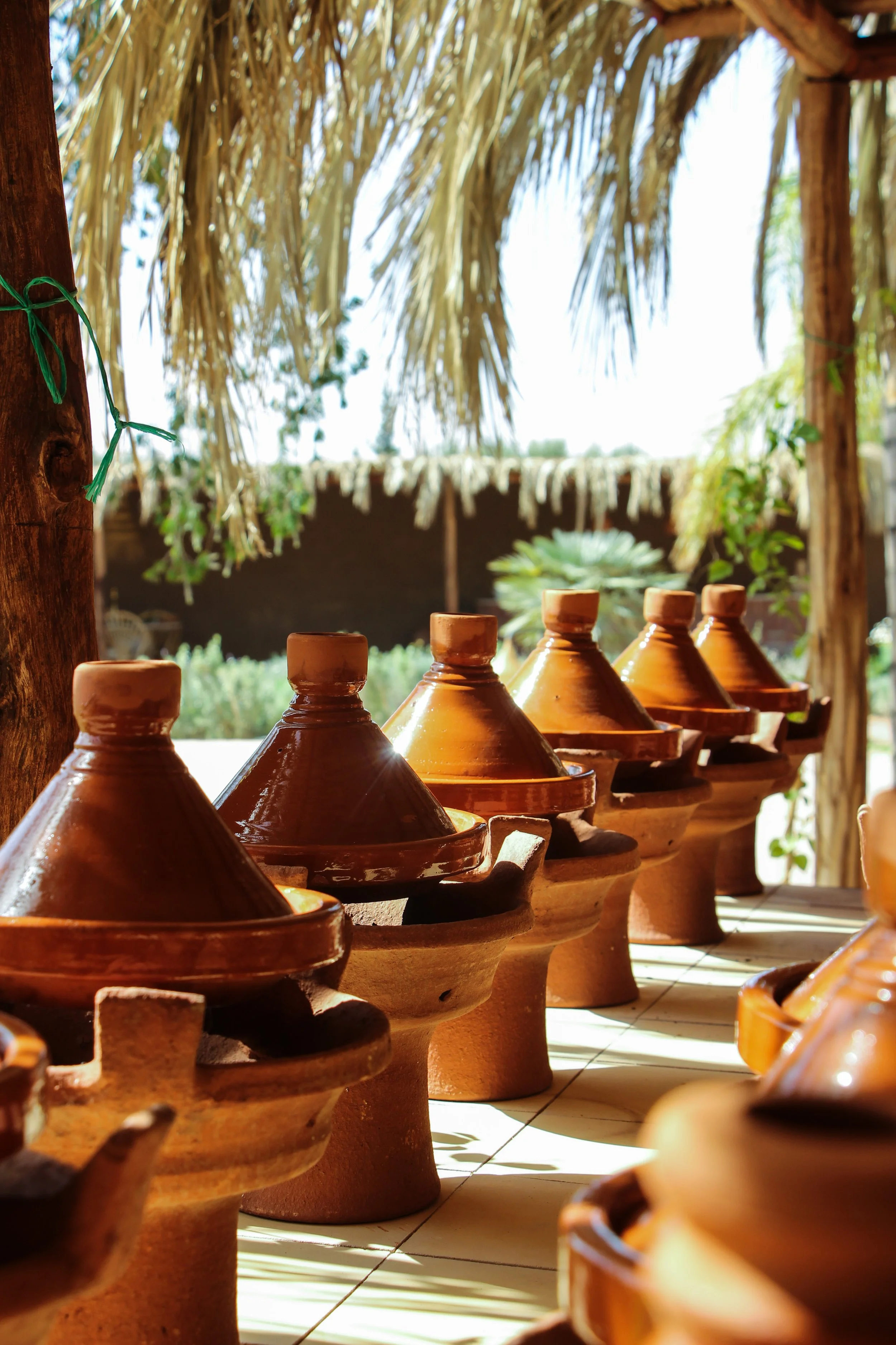 Guests cooking their own traditional Moroccan tajines lined up at the Marrakech farmhouse cooking class