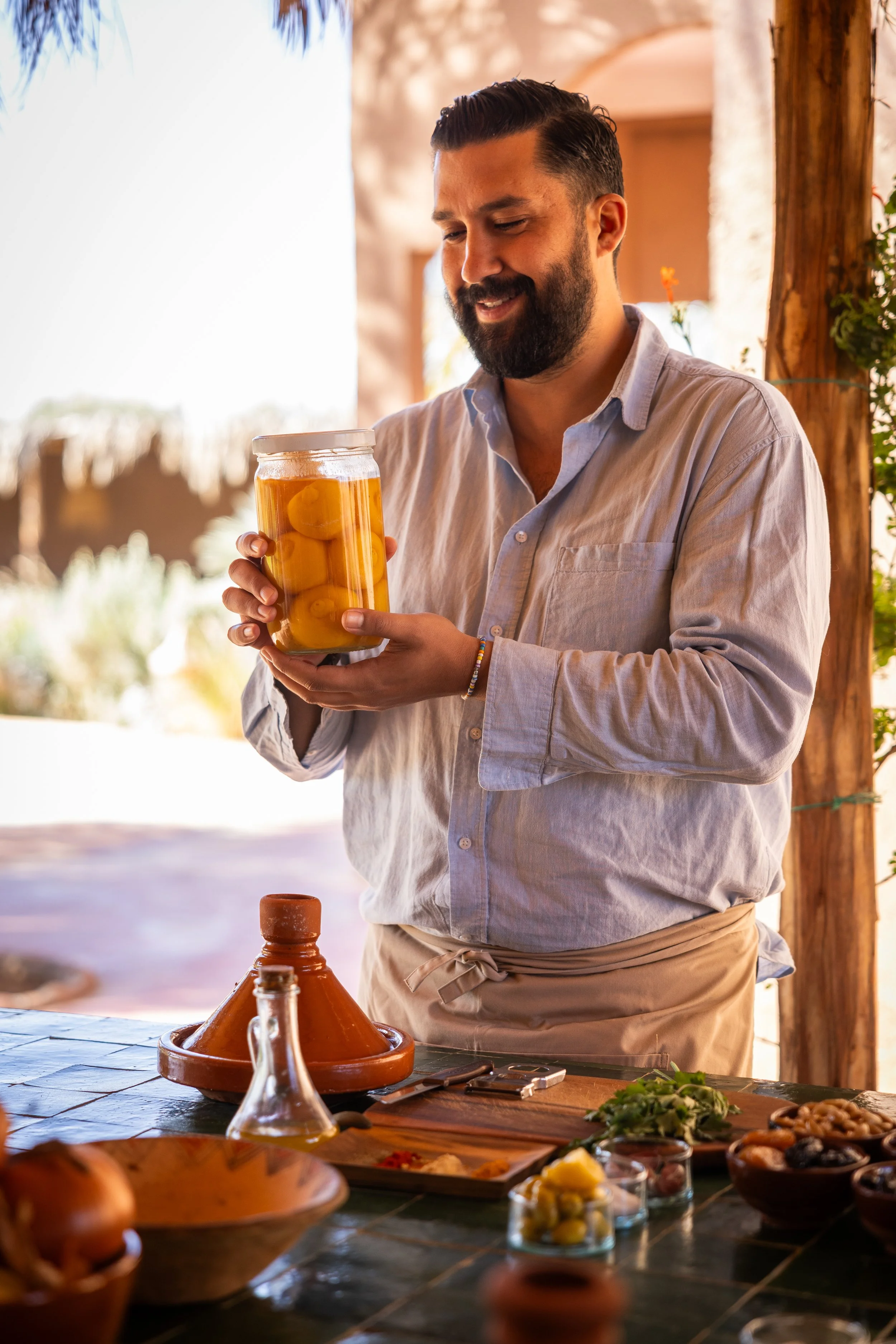 Host holding preserved lemons and explaining their use during a Moroccan cooking class