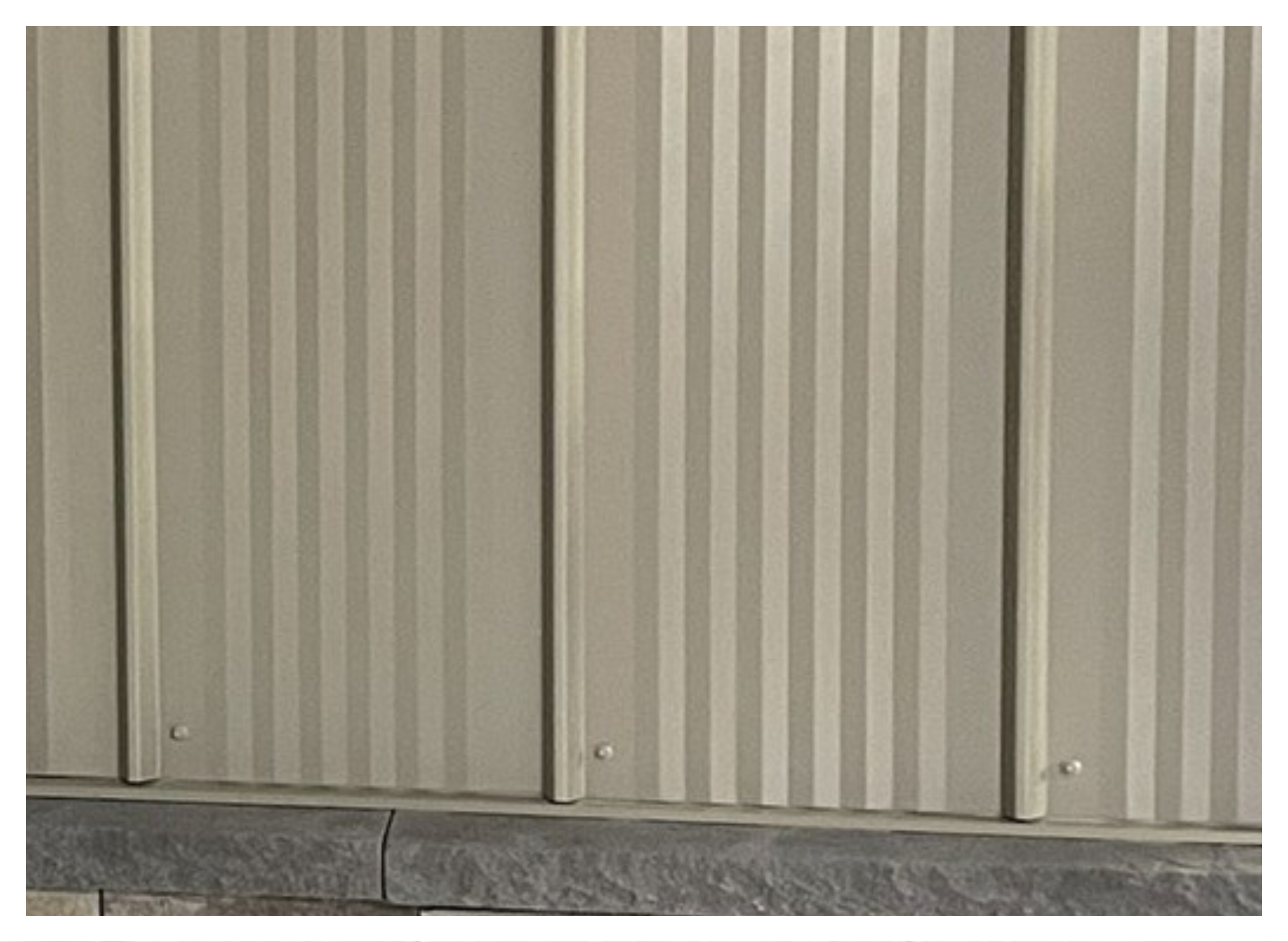 Close-up of a beige m panel metal siding.