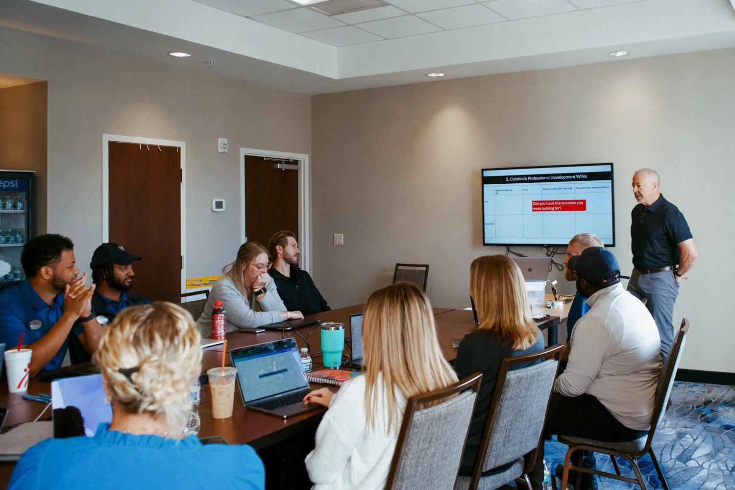 Daniel Allen leads a team meeting featuring a diverse group of young leaders.