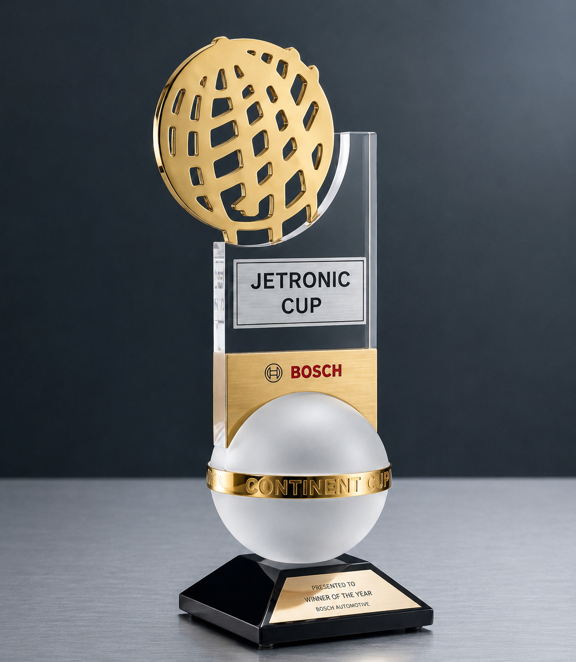 A trophy with a gold globe at the top, a silver plaque labeled 'JETRONIC CUP', a gold section with Bosch logo, a white globe with a gold band labeled 'CONTINENT CUP', and a black base with a gold plaque reading 'Presented to Winner of the Year Bosch 