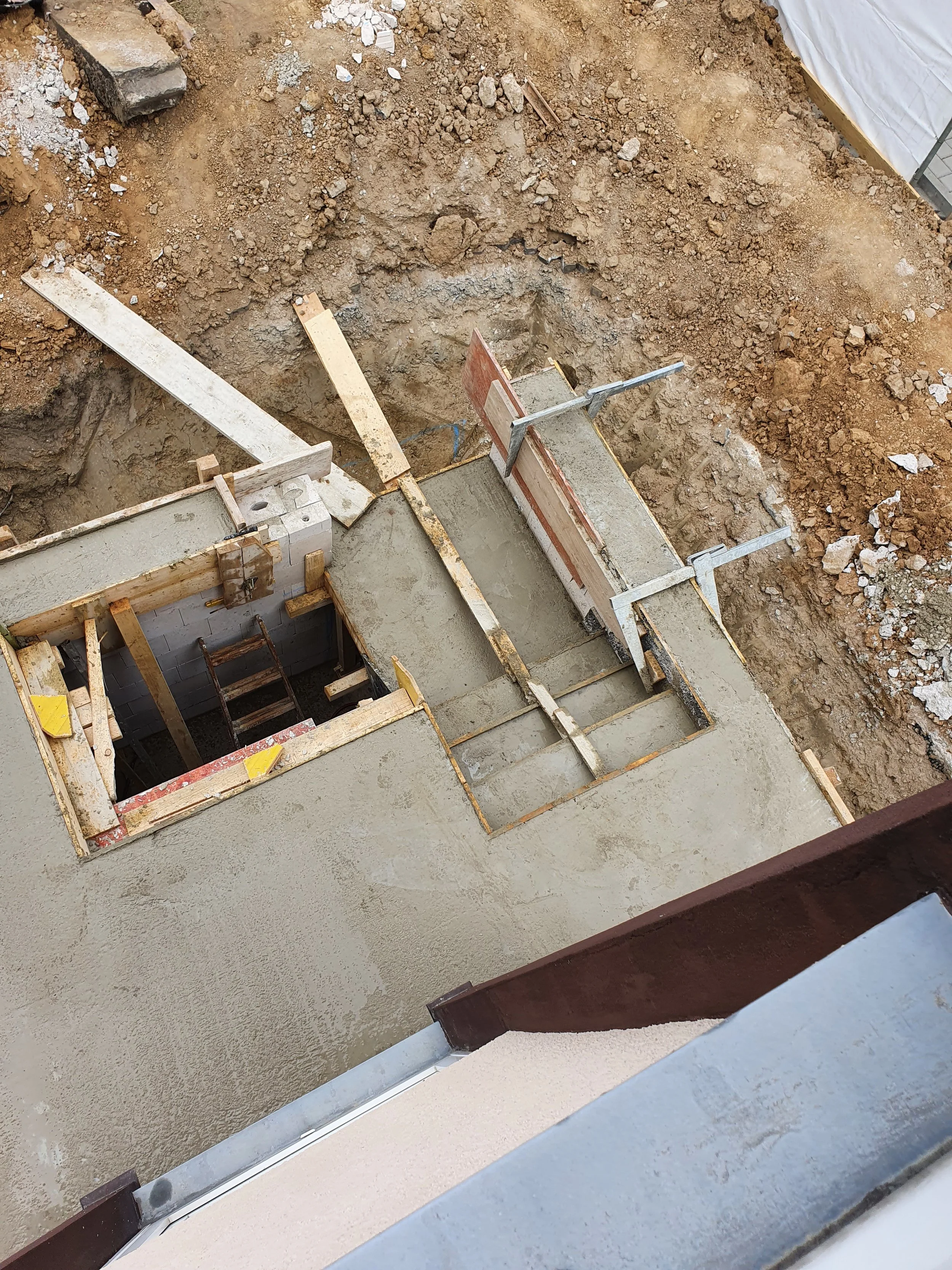 Bauarbeiten an einer Terrassen- oder Balkondecke, bestehend aus frisch gegossenem Beton, mit Holz- und Metalldorn.