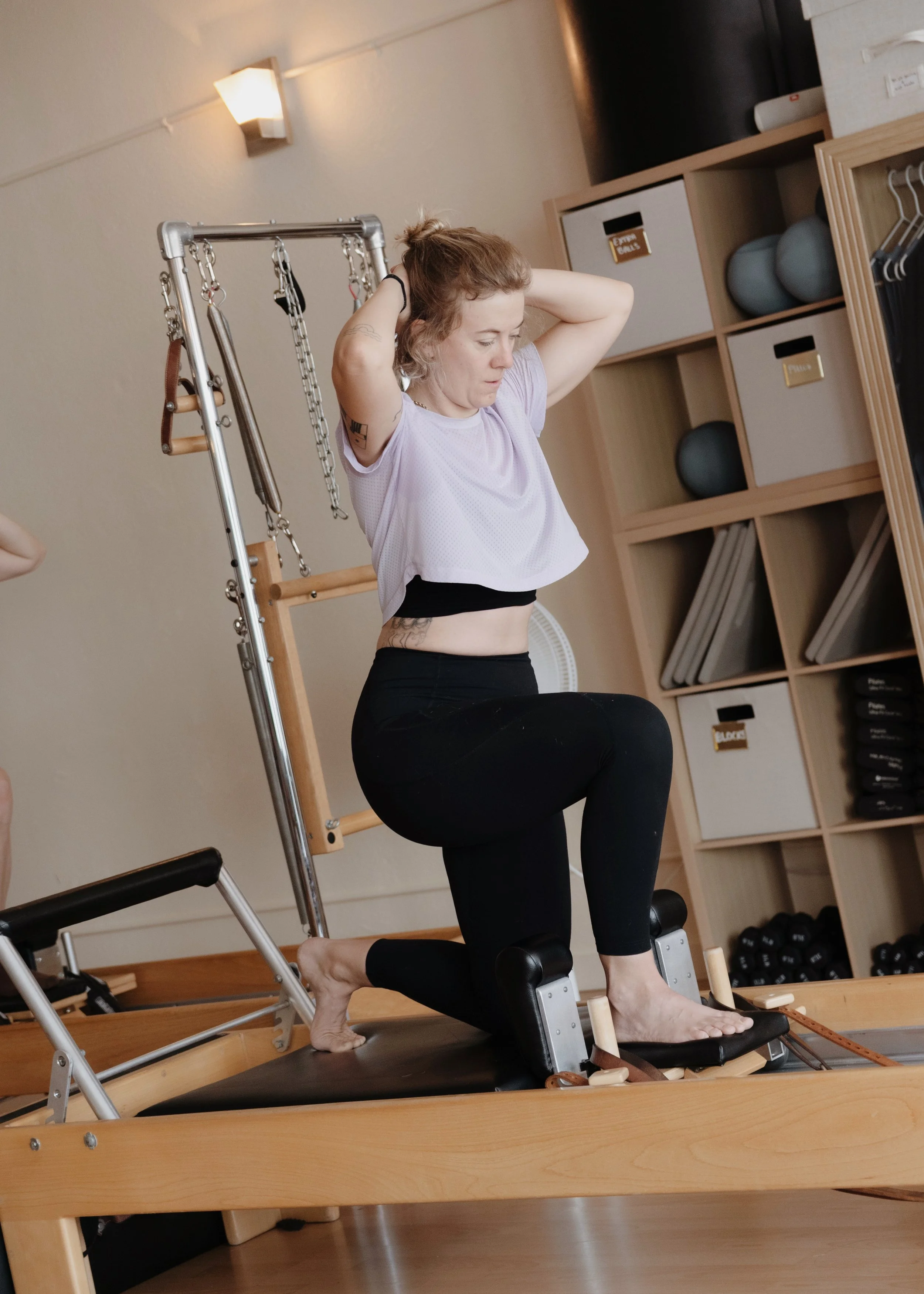 Woman using a reformer during her Pilates workout.