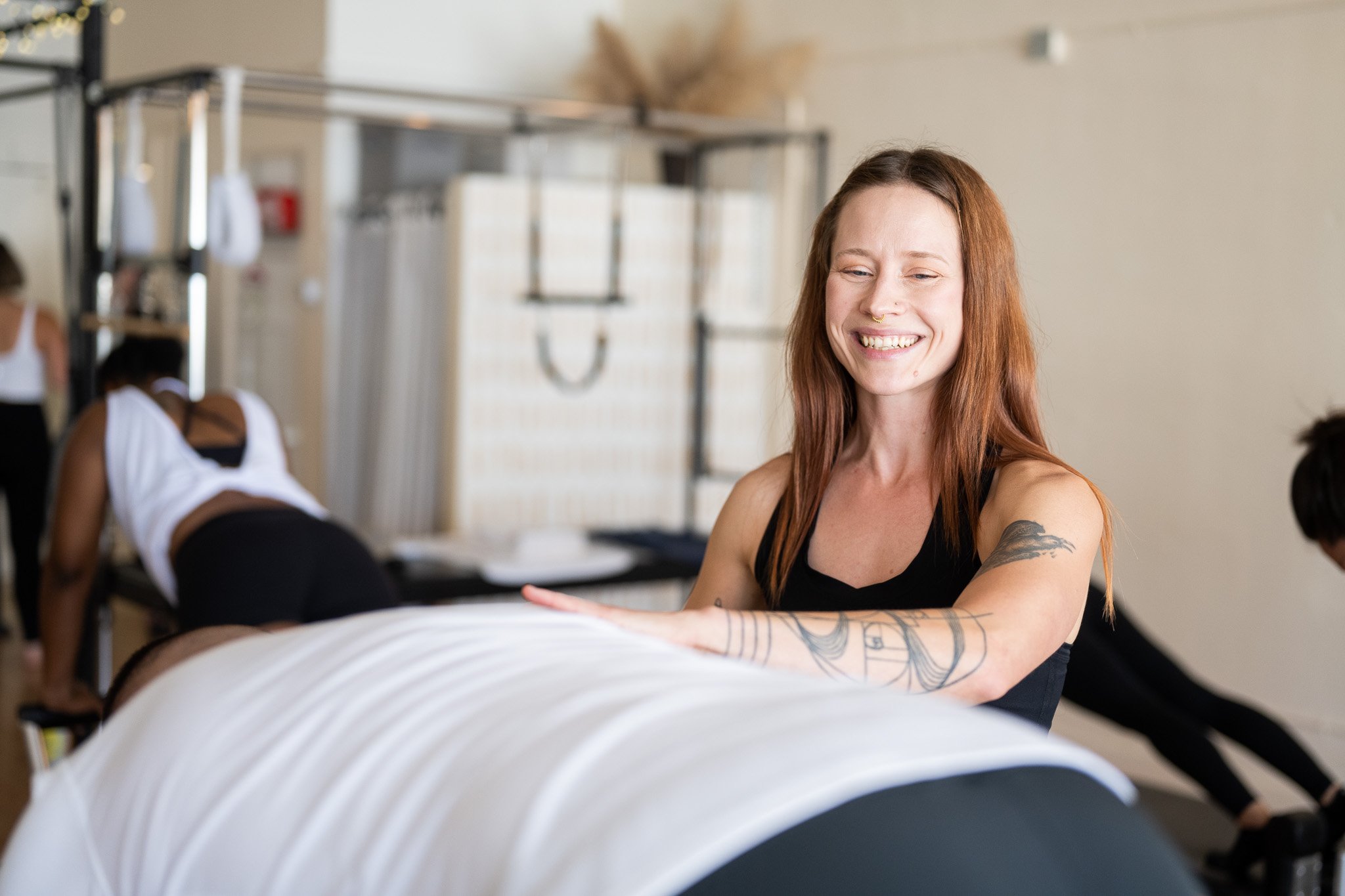 Pilates instructor guiding students on proper form during class.