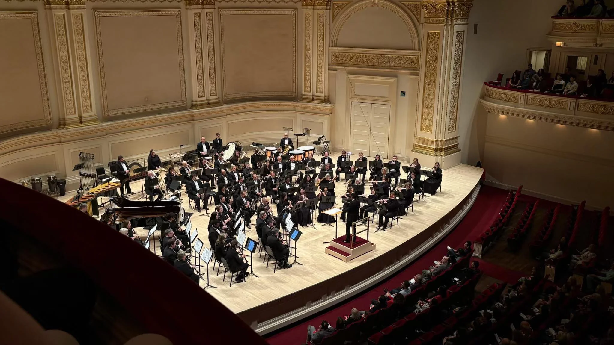 Tara Winds performing at Carnegie Hall with an audience seated in front and balconies on both sides.