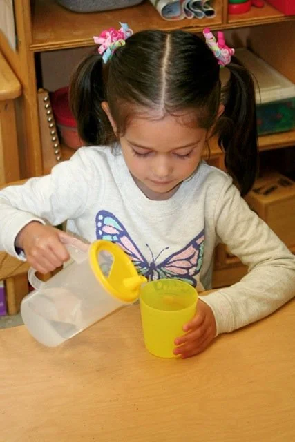 SELF-HELP SKILLS:  We patiently support children as they learn to put on their own shoes, zip jackets, pour their own water. Through daily routines and thoughtful encouragement, children develop essential self-help skills that build confidence and ca