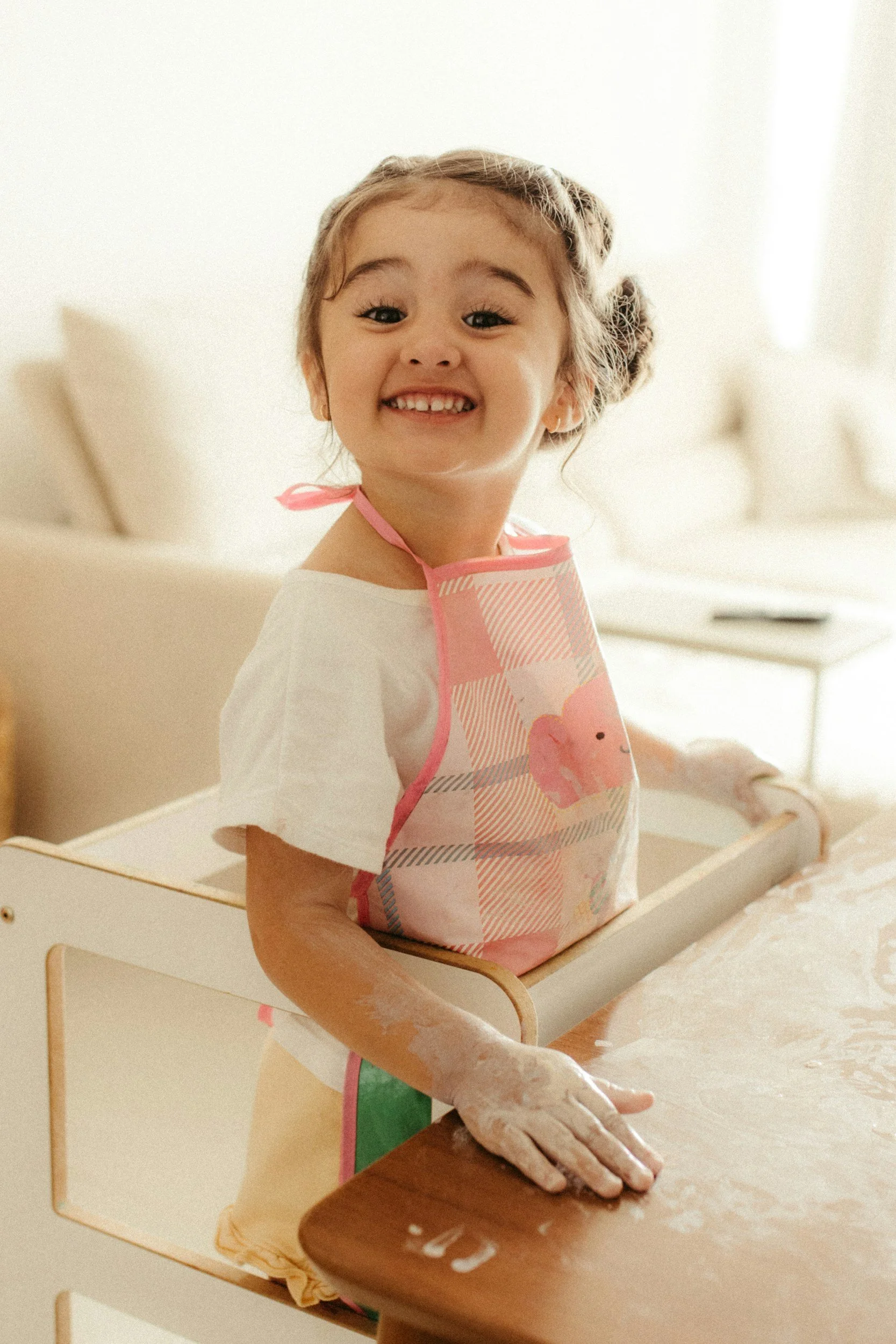 child standing on a montessori learning tower