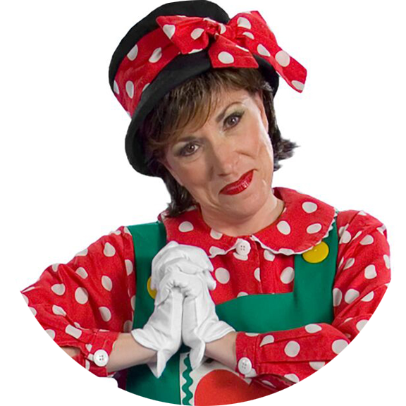 Woman dressed as Minnie Mouse with red polka dot dress, matching bow hat, white gloves, and green suspenders making a prayer gesture.