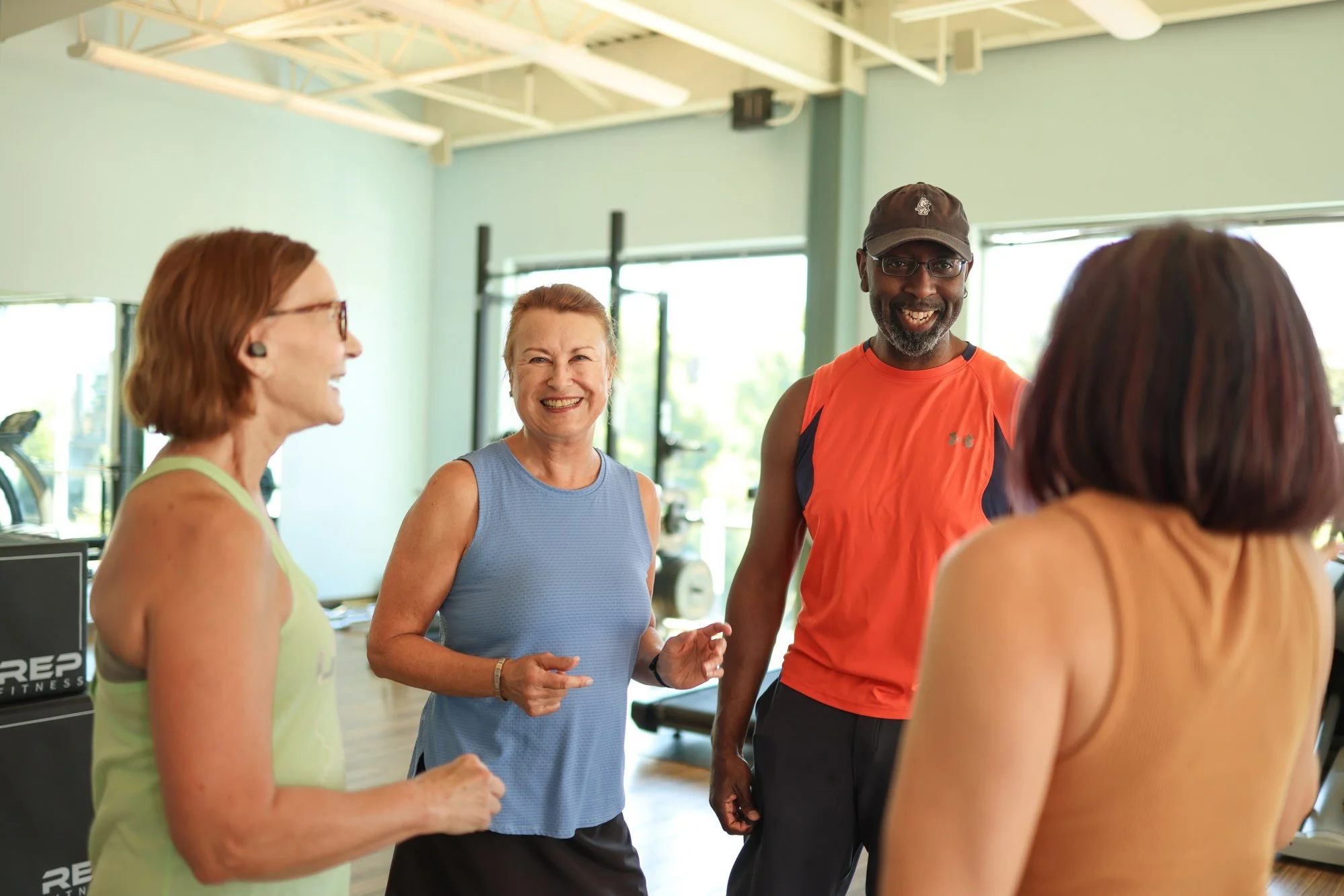 Group laughing and talking in a gym.