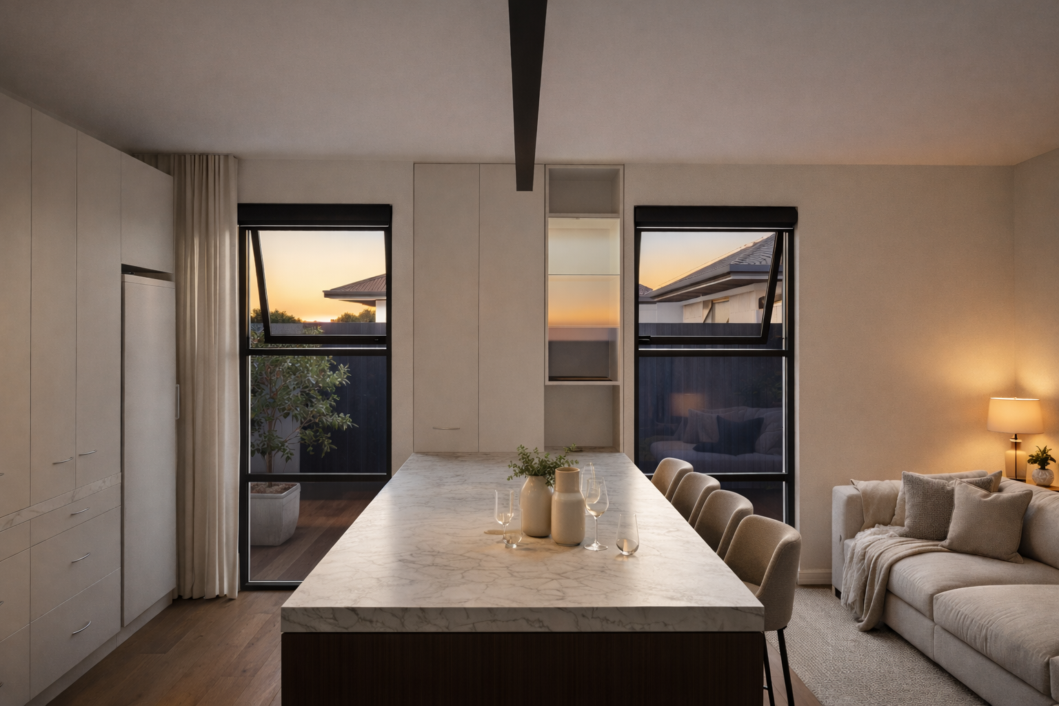 Modern dining and living room with a marble-top table, beige chairs, a white sofa with cushions, a side lamp on a table with a potted plant, and open windows showing a sunset sky  in Blenheim New Zealand