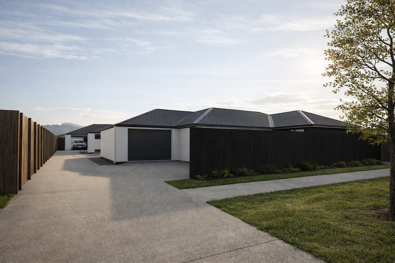 Modern house with a dark roof and white walls, surrounded by a black wooden fence and a well-maintained lawn, with a concrete driveway, parked car, and a tree on the right side  in Blenheim New Zealand