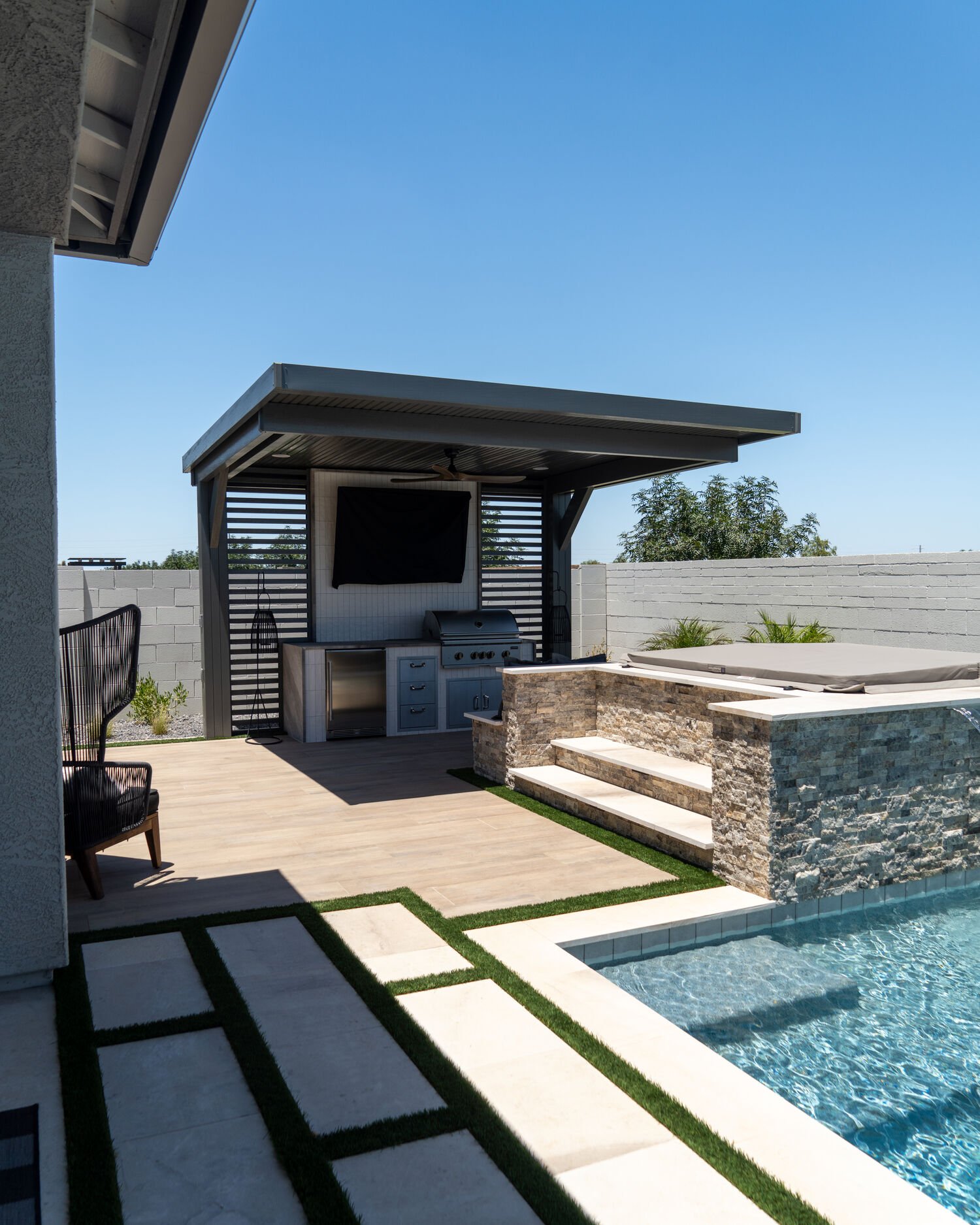 Backyard outdoor kitchen in Queen Creek, AZ with built-in grill, outdoor kitchen cabinets and landscape design