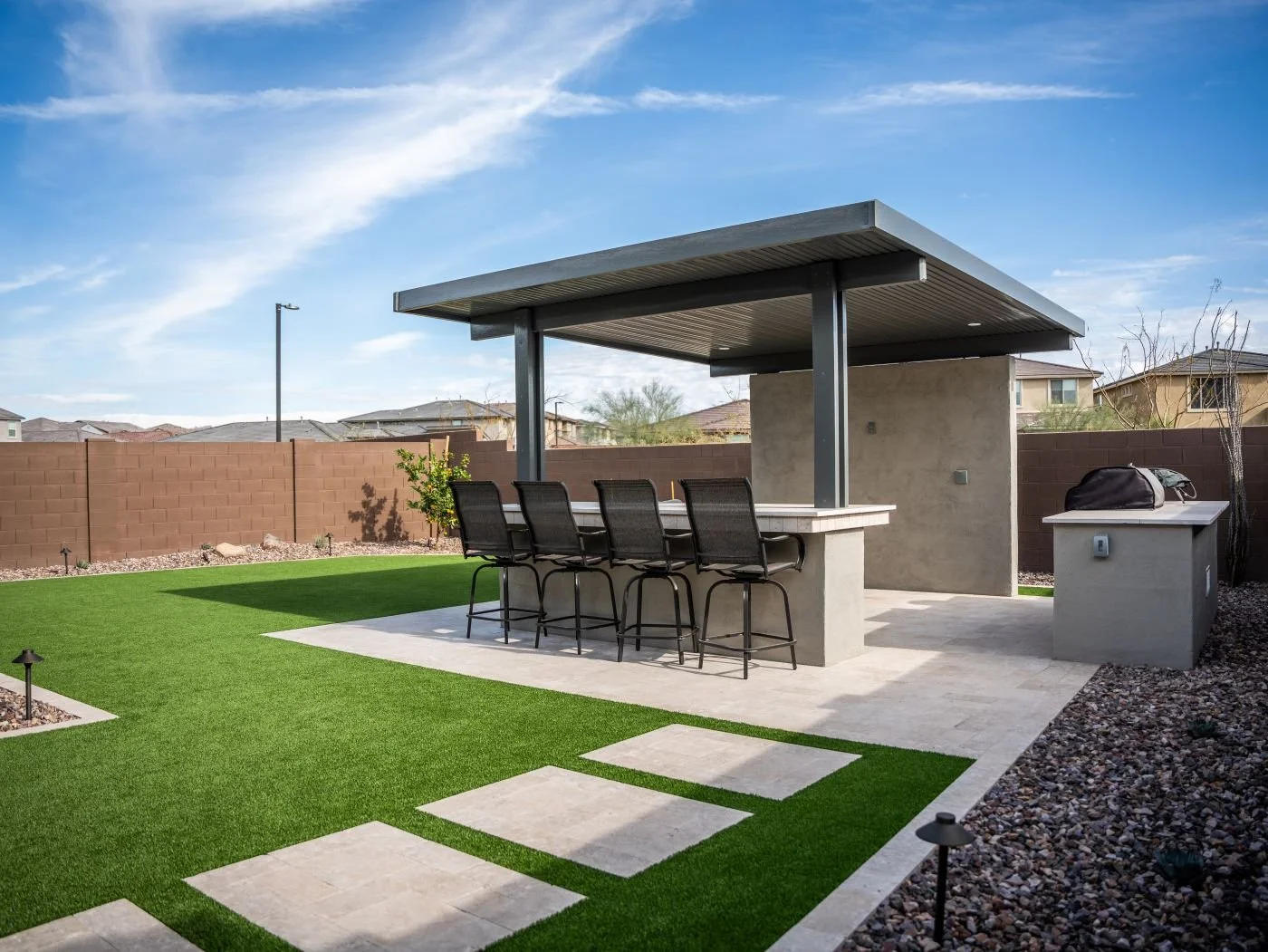 Covered pergola dining area with paver patio and landscape design in Gilbert, AZ